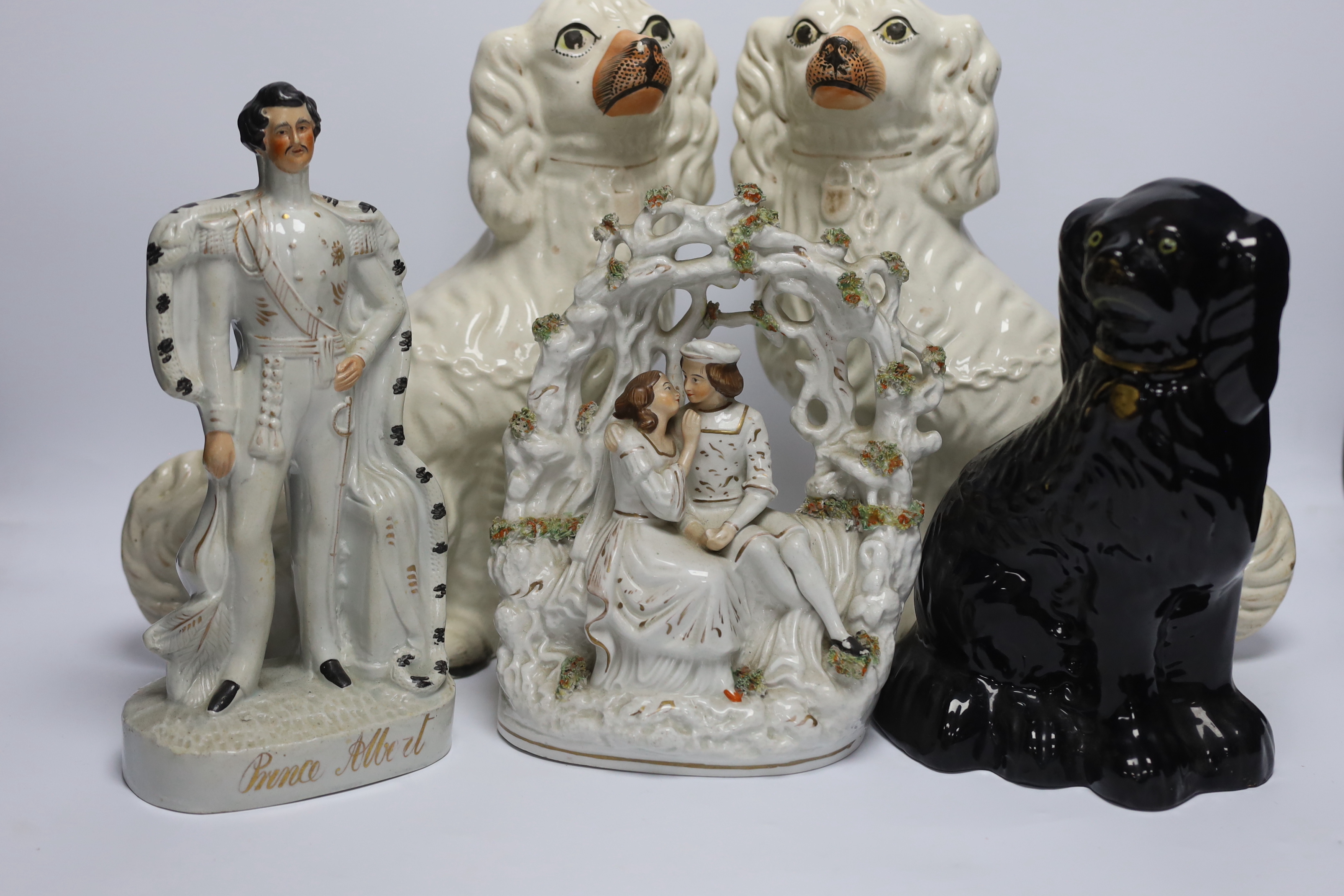 A mixed collection of Staffordshire figure groups to include various spaniels, a Prince Albert figure, courting couples and other bocage groups